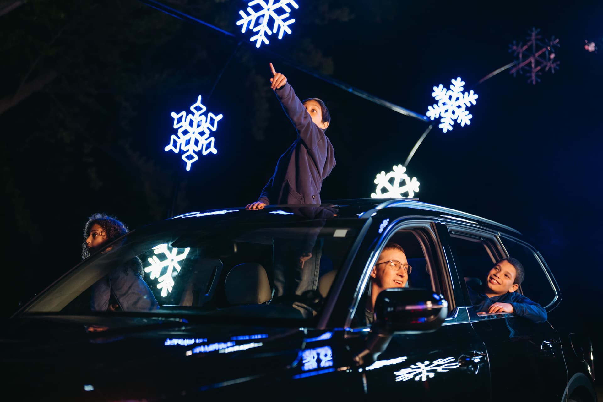 Family enjoying winter wonderland with illuminated snowflake decorations